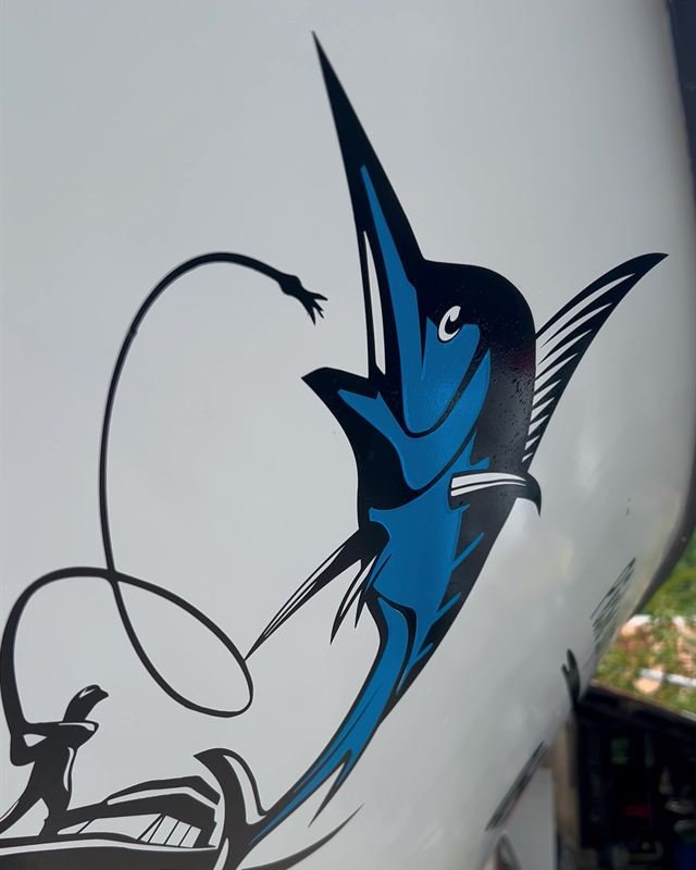 Marquage adhésif d'un marlin et d'un pêcheur sur la coque d'un bateau de pêche