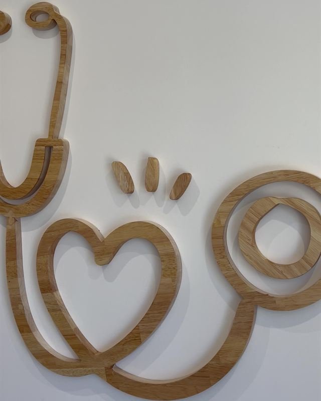 Logo du Village Médical en bois découpé, posé au mur